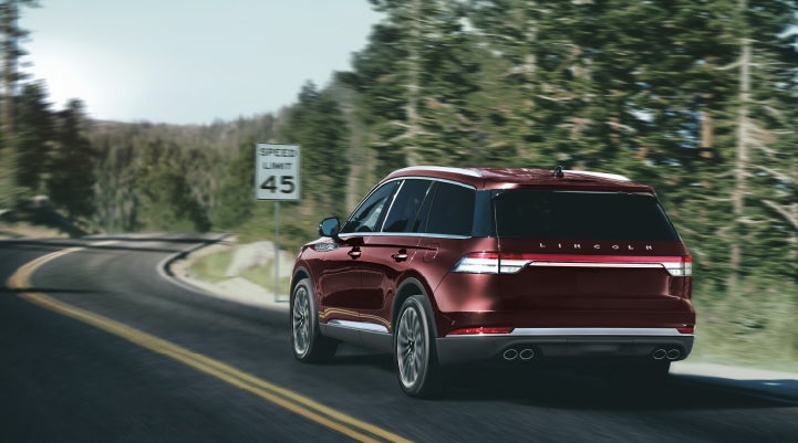 A 2024 Lincoln Aviator® SUV is being driven on a winding mountain road | Crossroads Lincoln of Southern Pines in Southern Pines NC